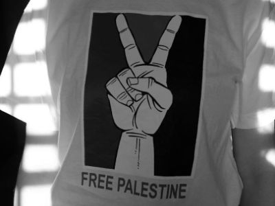 The white shirt has a peace sign with the text free Palestine written below it.